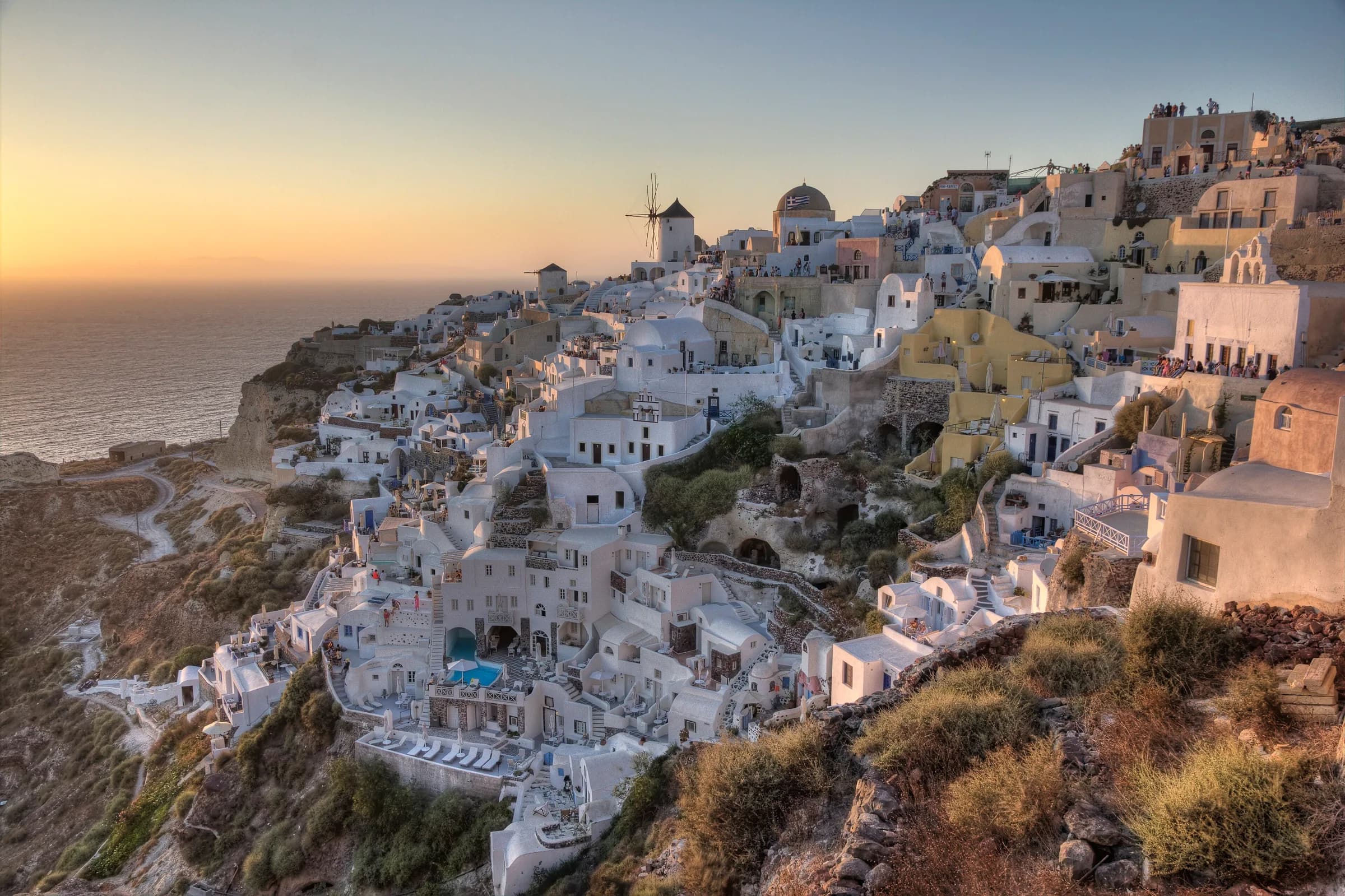 Whitewashed clifftop village of Oia in Santorini at sunset, Greece